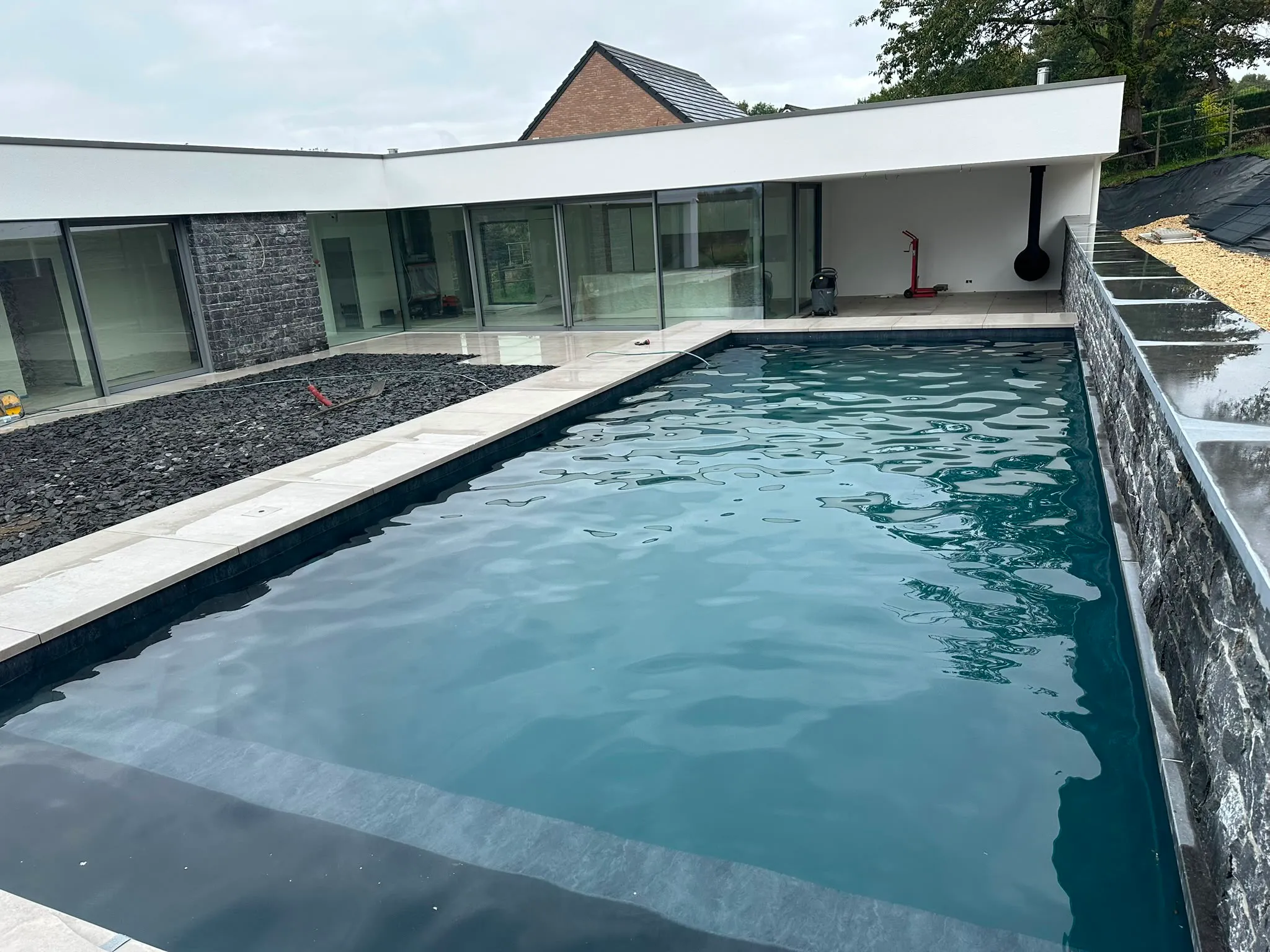 Vue rapprochée d’une piscine contemporaine le long d’un mur en pierre