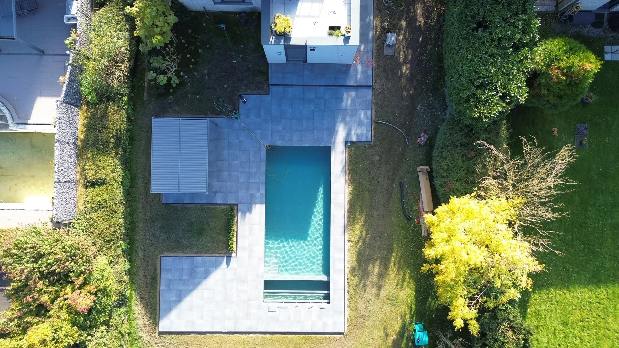 Vue verticale aérienne d’une piscine rectangulaire et de sa terrasse
