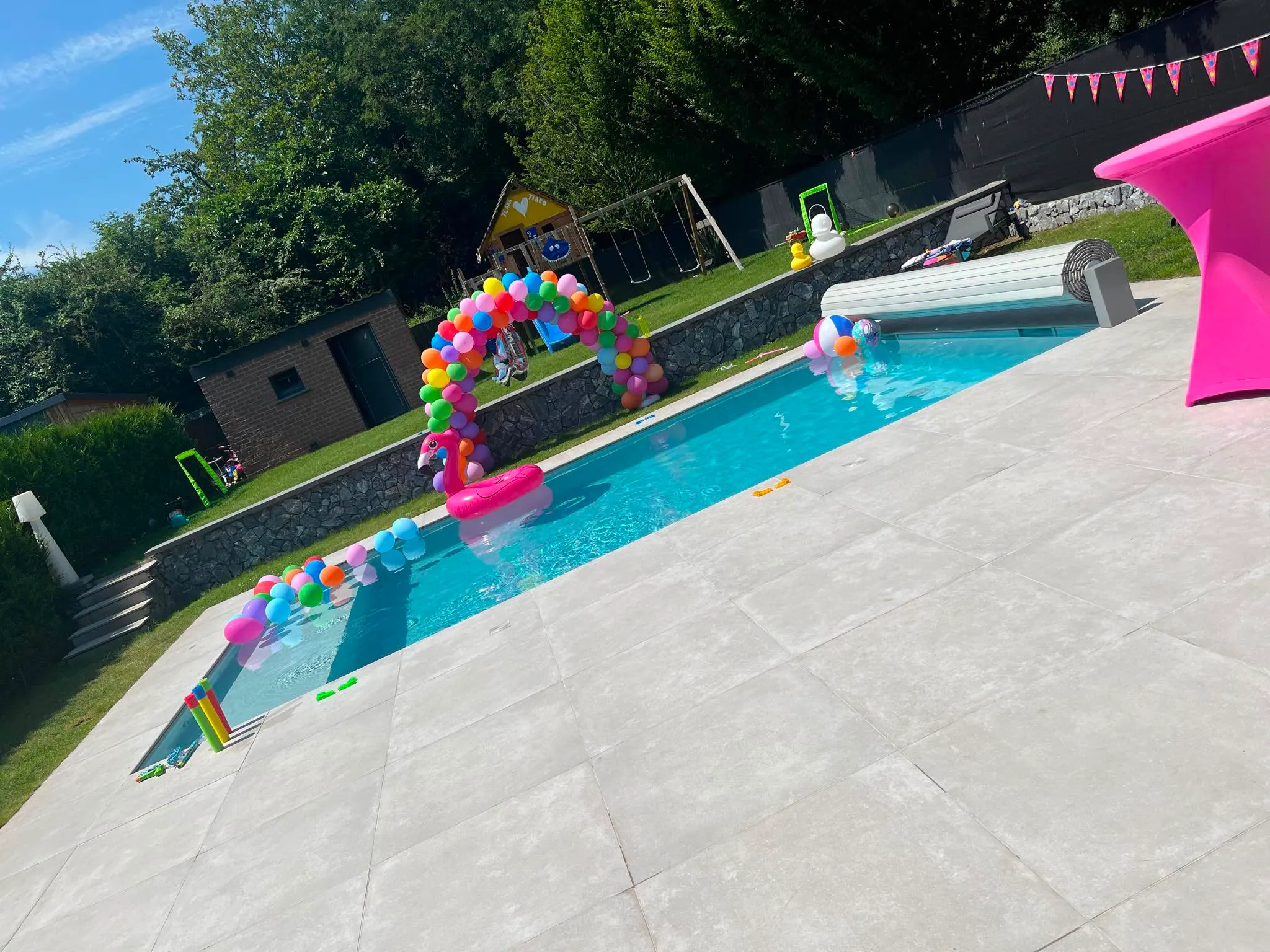 Piscine aménagée pour une fête familiale avec terrasse et jardin