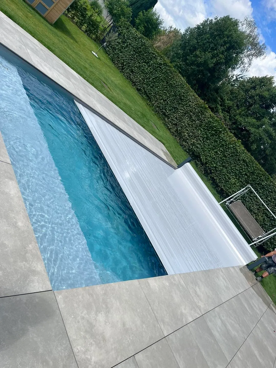 Volet automatique se déployant sur une piscine avec grande plage immergée