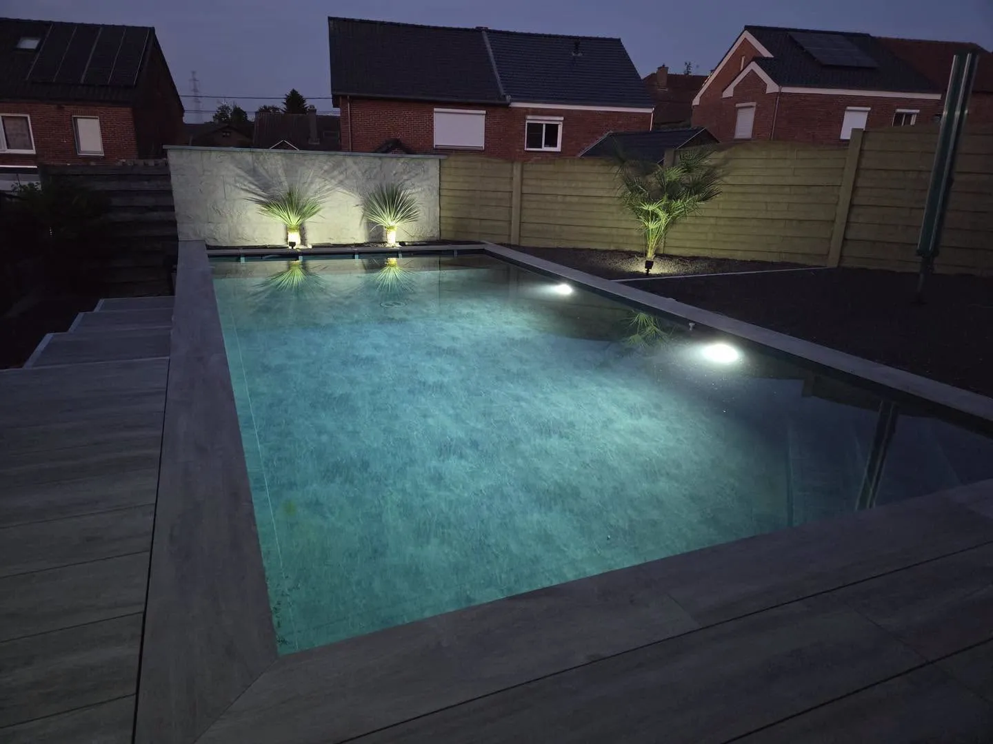 Piscine éclairée en soirée avec mise en lumière des plantations